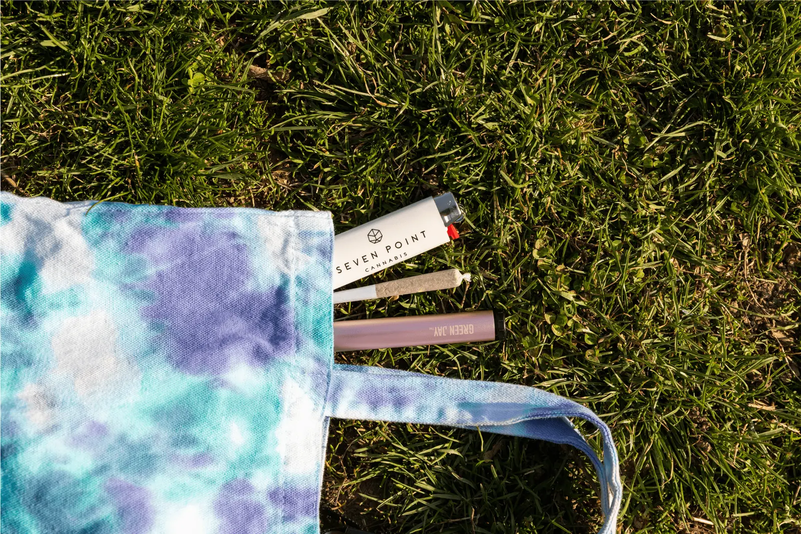 Seven Point Cannabis tote bag with pre-rolls on the grass